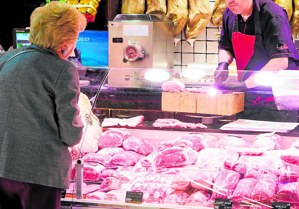 Una clienta pide en una carniceria.