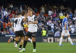 Dani Gómez celebra el 2-2 mientras Canós se dirige con el balón al círculo cnetral.