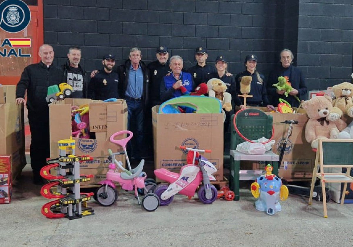 Policías y miembros del Banco de Alimentos posan junto a los juguetes.