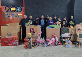 Policías y miembros del Banco de Alimentos posan junto a los juguetes.