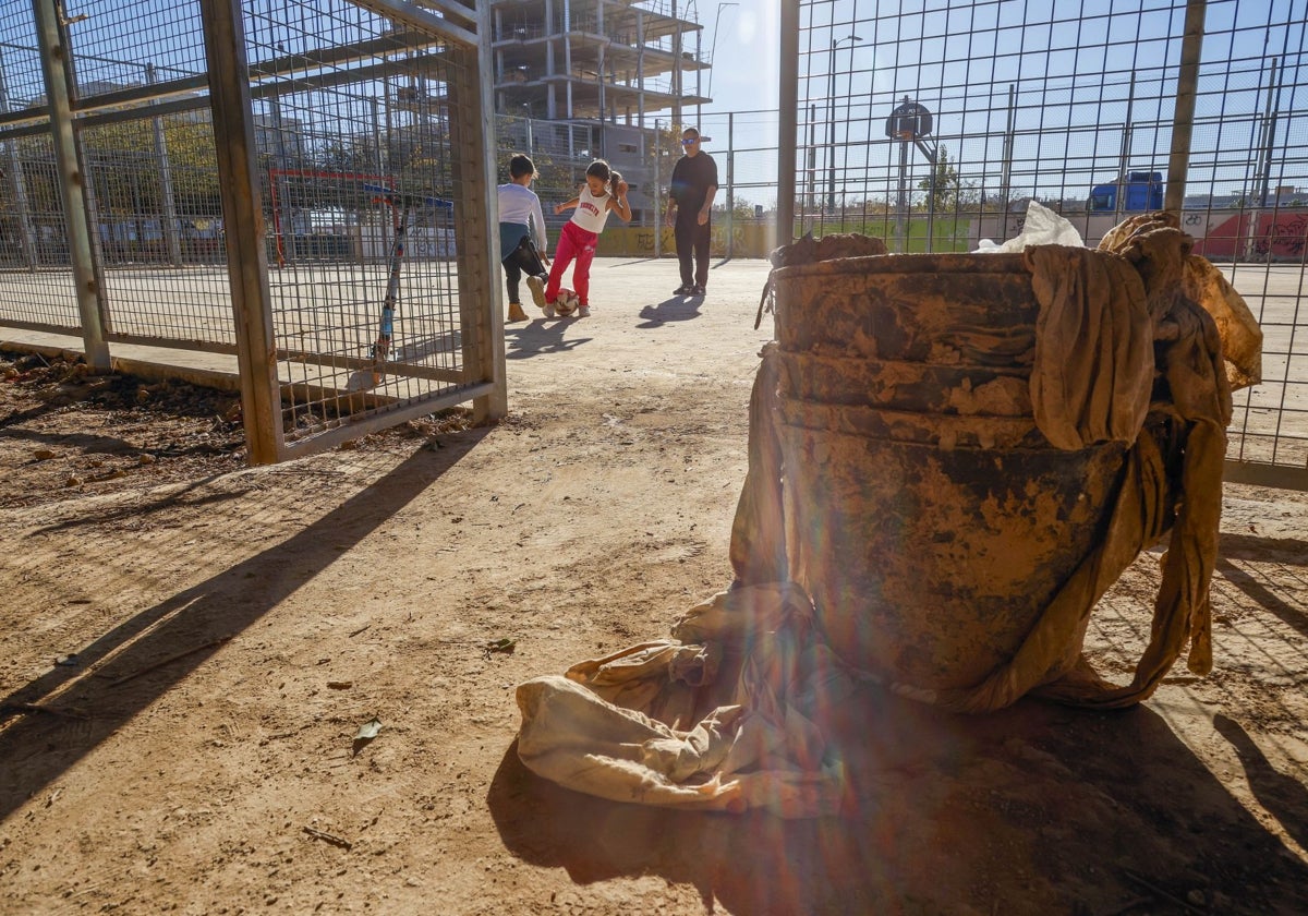 Alejandro juega a fútbol con sus dos hijos en el parque Paluzié, en Catarroja.