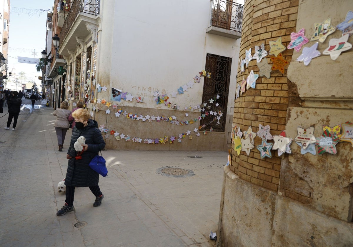 Paredes manchadas de barro en Paiporta, engalanadas con adornos elaborados por niños.