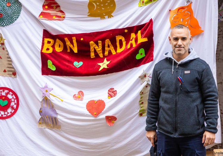 Juan, vecino de Paiporta, junto a un cartel navideño en su pueblo.