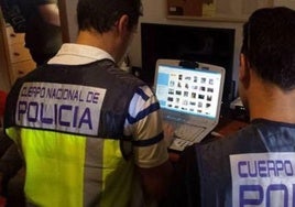 Dos policías nacionales revisan un ordenador en una imagen de archivo.