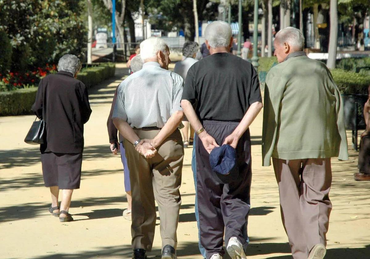 Pensionistas paseando por un parque, imagen de archivo.