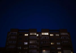 Varios hogares de un edificio encienden sus luces.