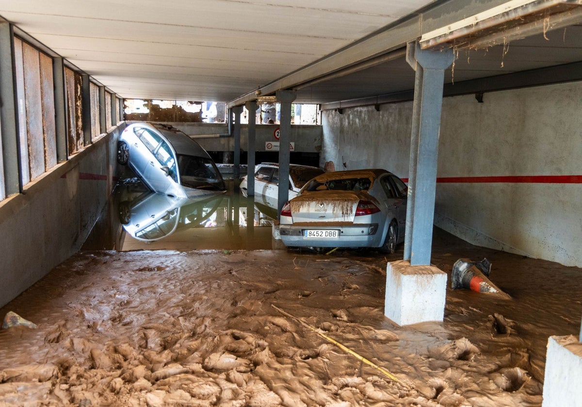 Un garaje de un edificio lleno de barro, agua y fango en Catarroja.