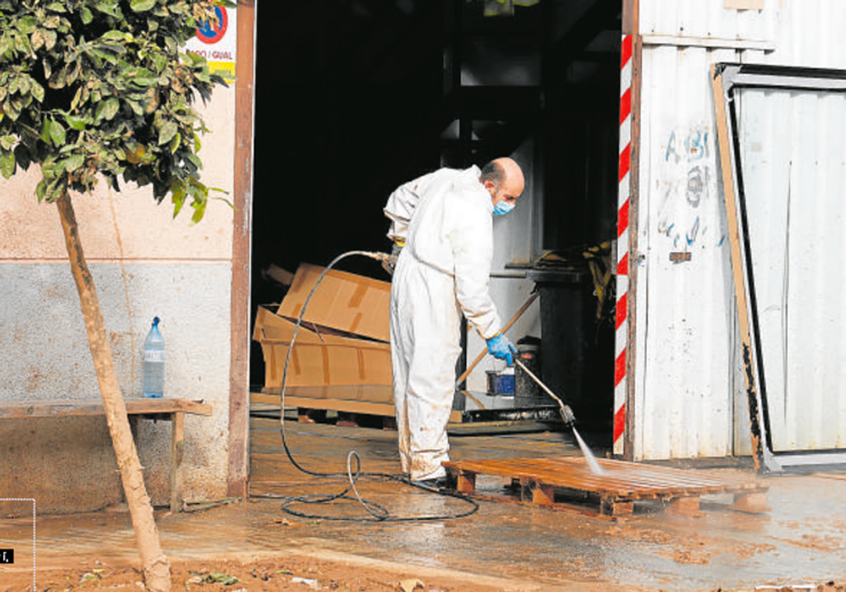 Un hombre limpia las instalaciones de una nave industrial.