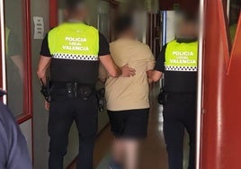 Dos agentes trasladan al detenido a la Unidad de Atestados de la Policía Local.