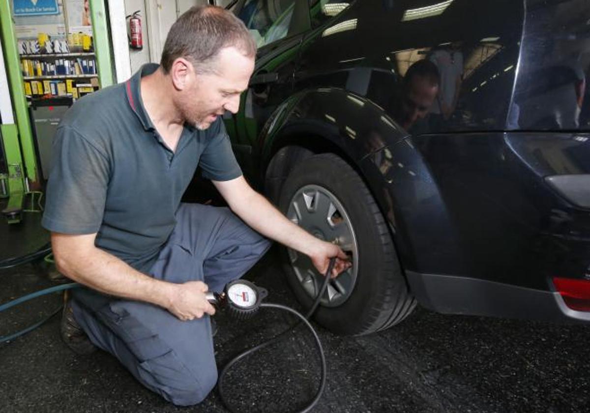 Un mecánico mide la presión de los neumáticos de un coche, en una imagen de archivo.