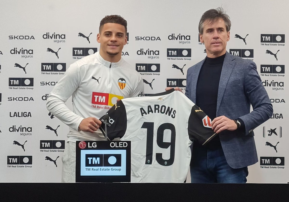 Max Aarons posa con la camiseta del Valencia junto a Miguel Ángel Corona.