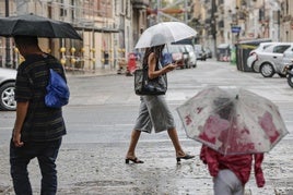 Ciudadanos pasean bajo el temporal. Imagen de archivo.