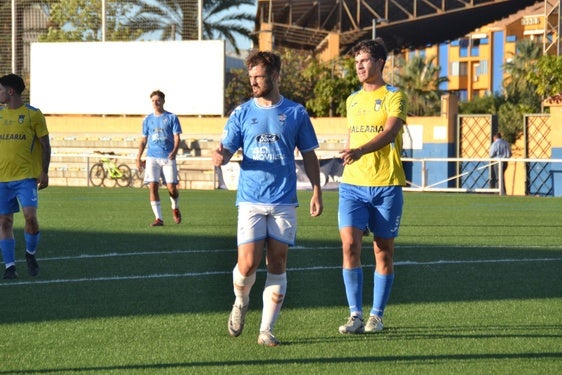 Un jugador del Independiente Alicante junto a otro del Dénia.