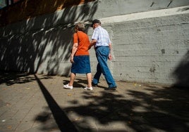 Dos jubilados pasean por una calle.