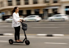 Una mujer recorre el carril bici de la calle Xàtiva en un patinete eléctrico.