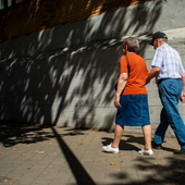 Dos jubilados pasean por una calle.