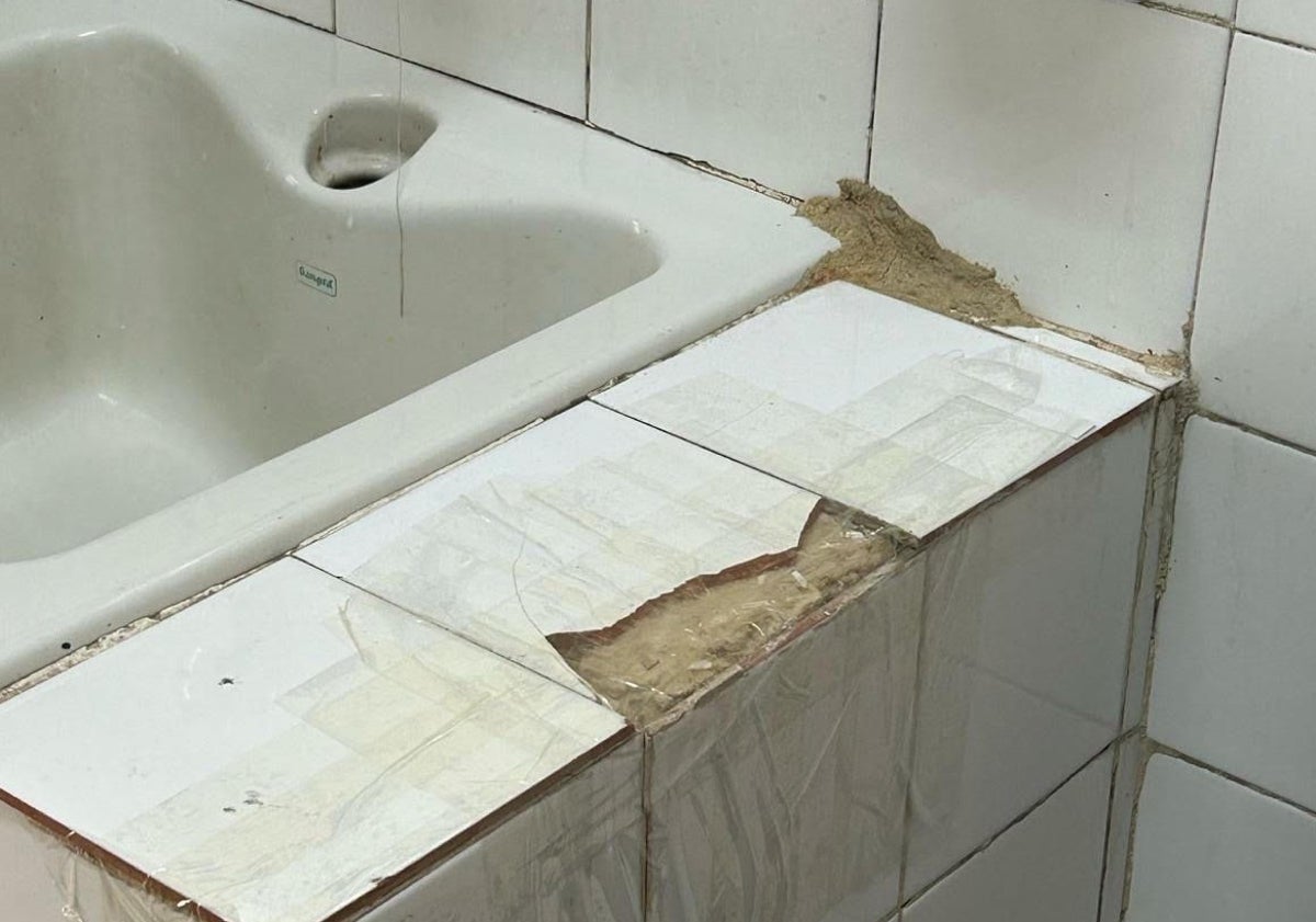 Imagen principal - Algunos de los desperfectos denunciados, como azulejos dañados, un desagüe sin retirar y el retrete sin uso almacenado en el baño. 