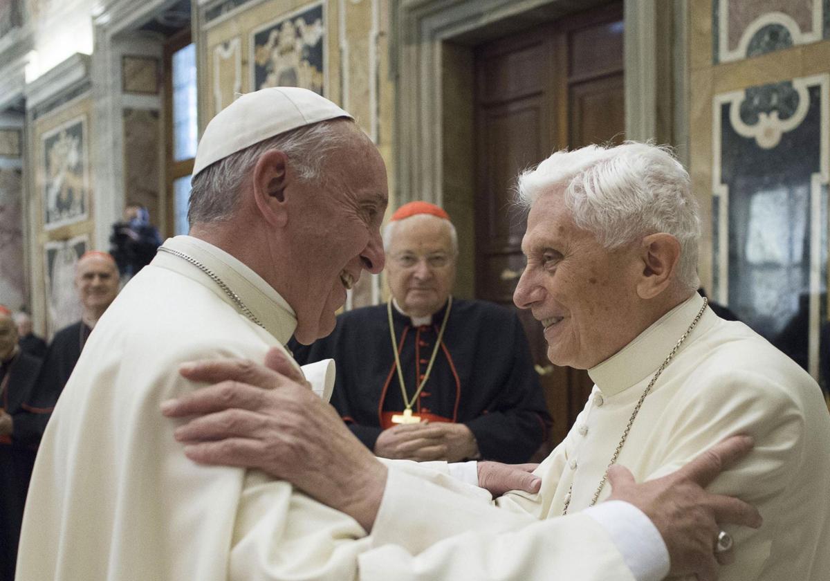 El papa Francisco (i) y el papa emérito Benedicto XVI (d) abrázandose durante una ceremonia.