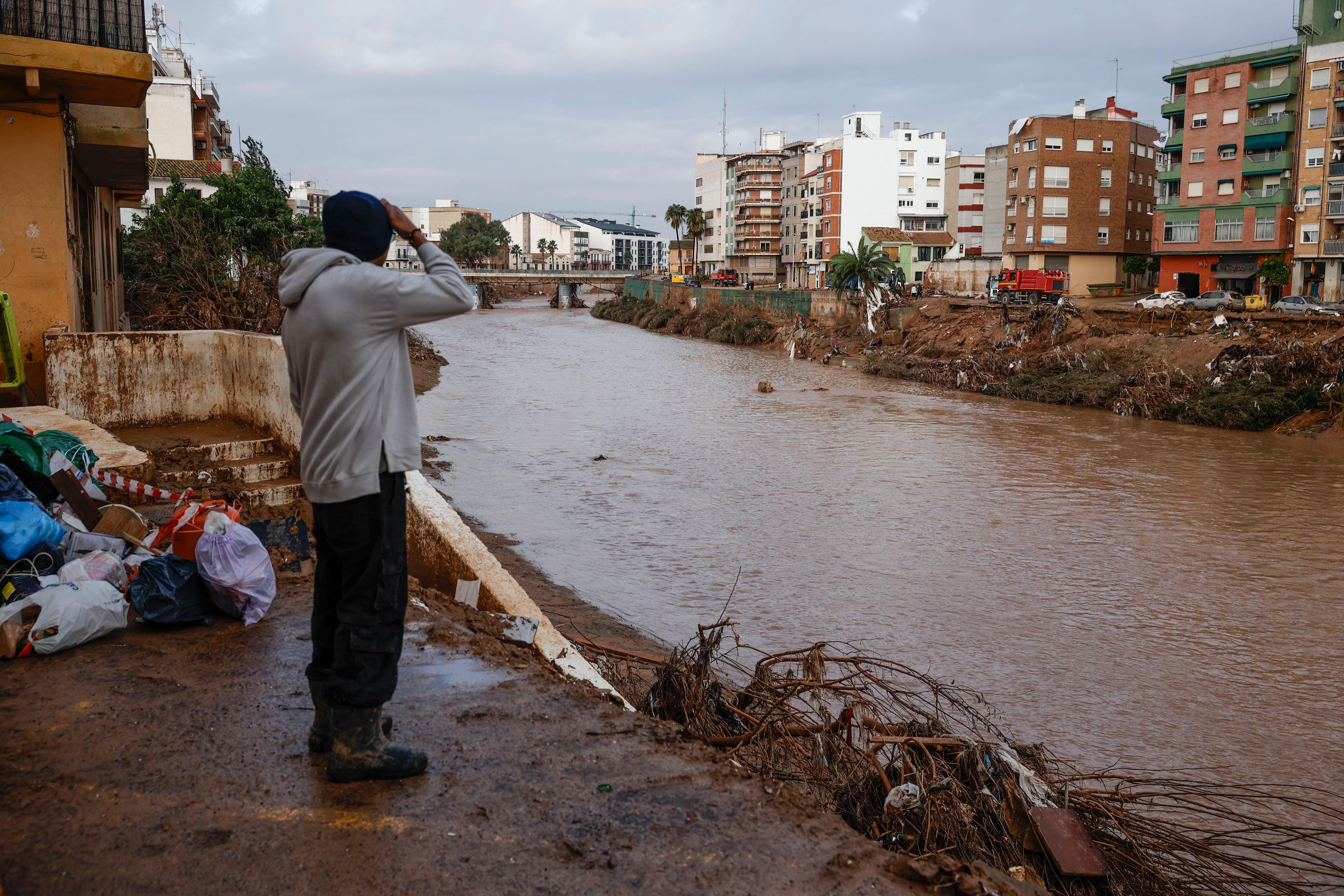 Un hombre observa la crecida del barranco del Poyo en Paiporta.