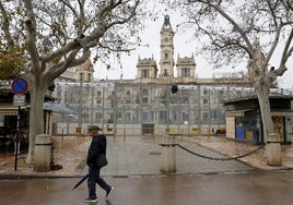 Un hombre pasa por la plaza del Ayuntamiento.