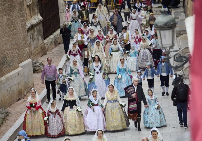 Falleras llegan por la calle del Miguelete a la plaza de la Virgen.