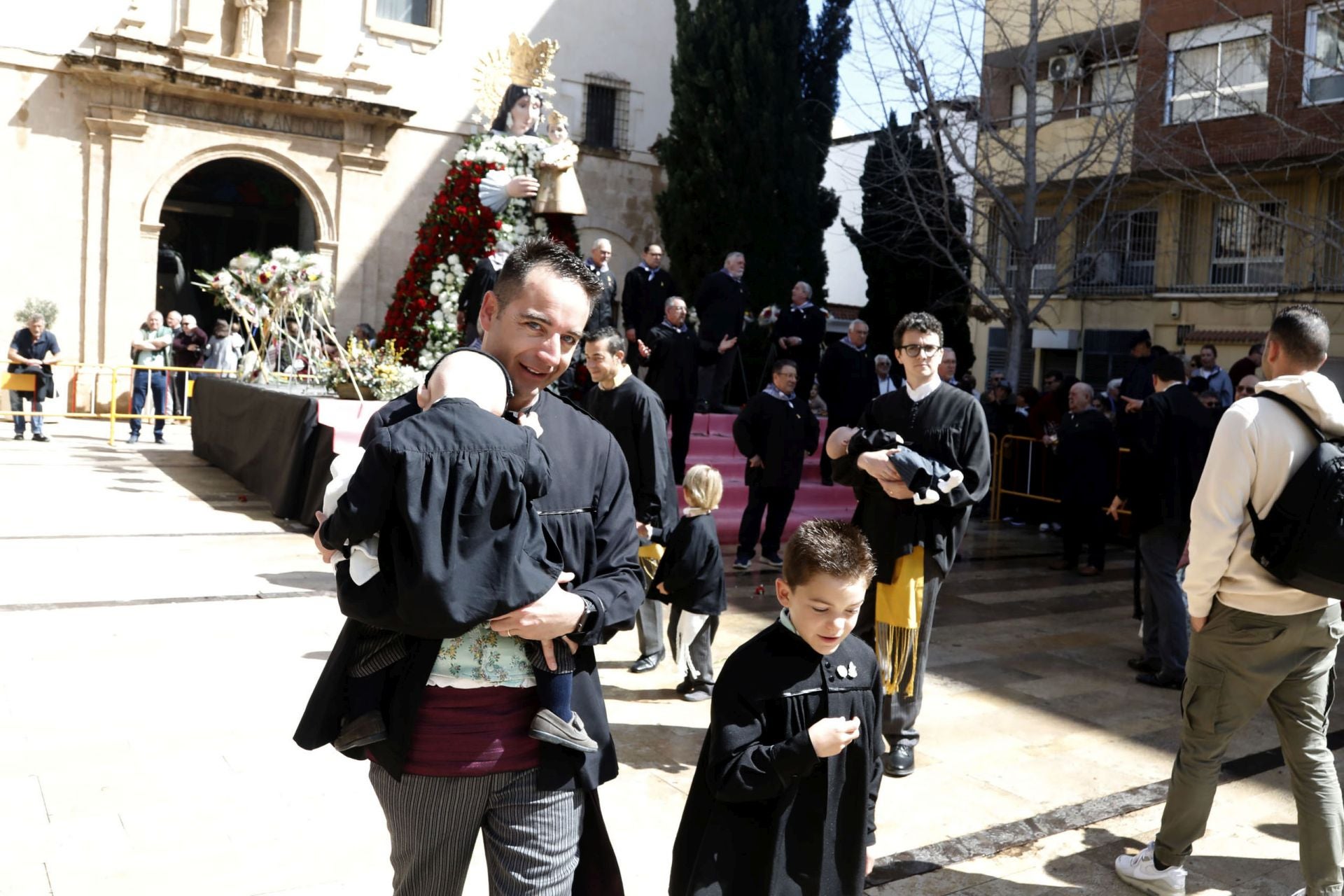 El pequeño Luca con su padre y u hermano y la 'xicalla' de Baix la Mar.