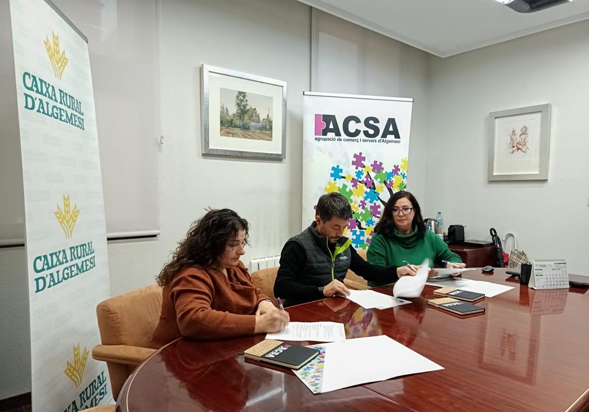 Firma del convenio entre los comerciantes y las dos entidades colaboradoras.