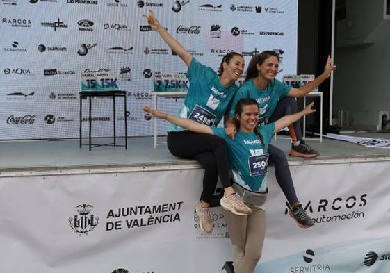 Tres amigas posan sonrientes en el podio después de completar la carrera del año pasado.