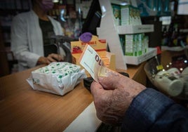 Un cliente paga en efectivo en una farmacia.