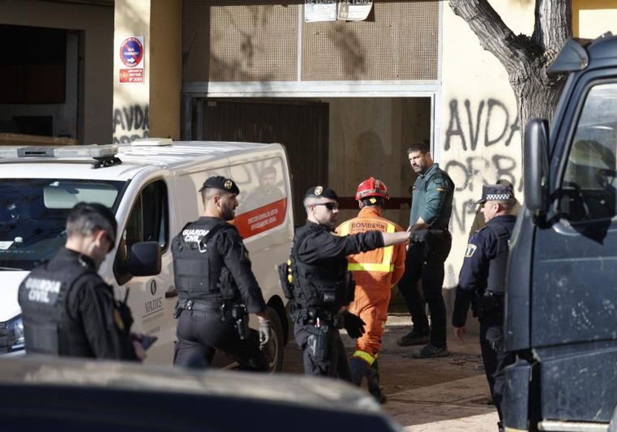 Tres guardias civiles y un bombero junto al furgón fúnebre en la dana.