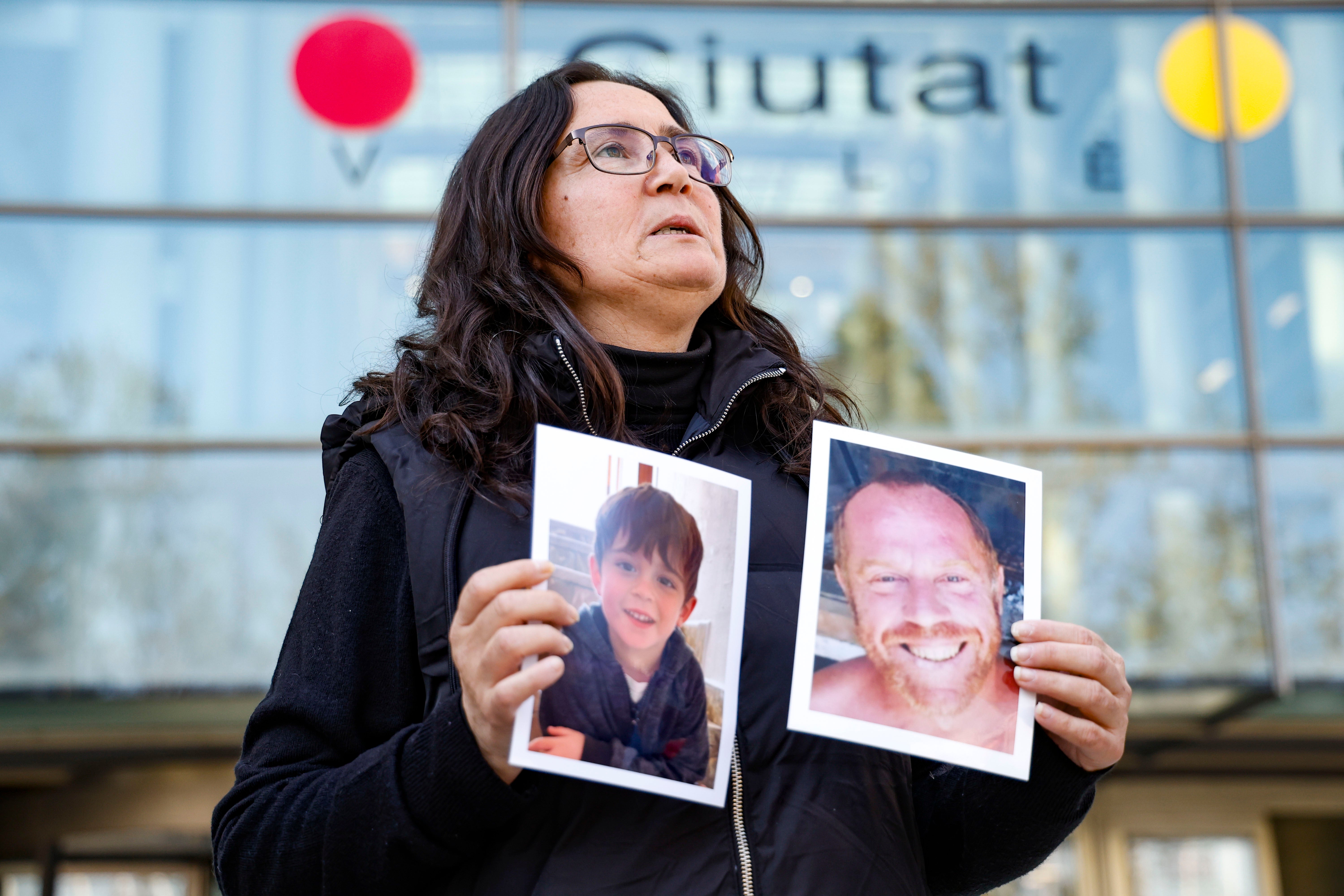 Ana María Coll, al llegar a la Ciudad de la Justicia, con las fotos de su hijo y su marido.