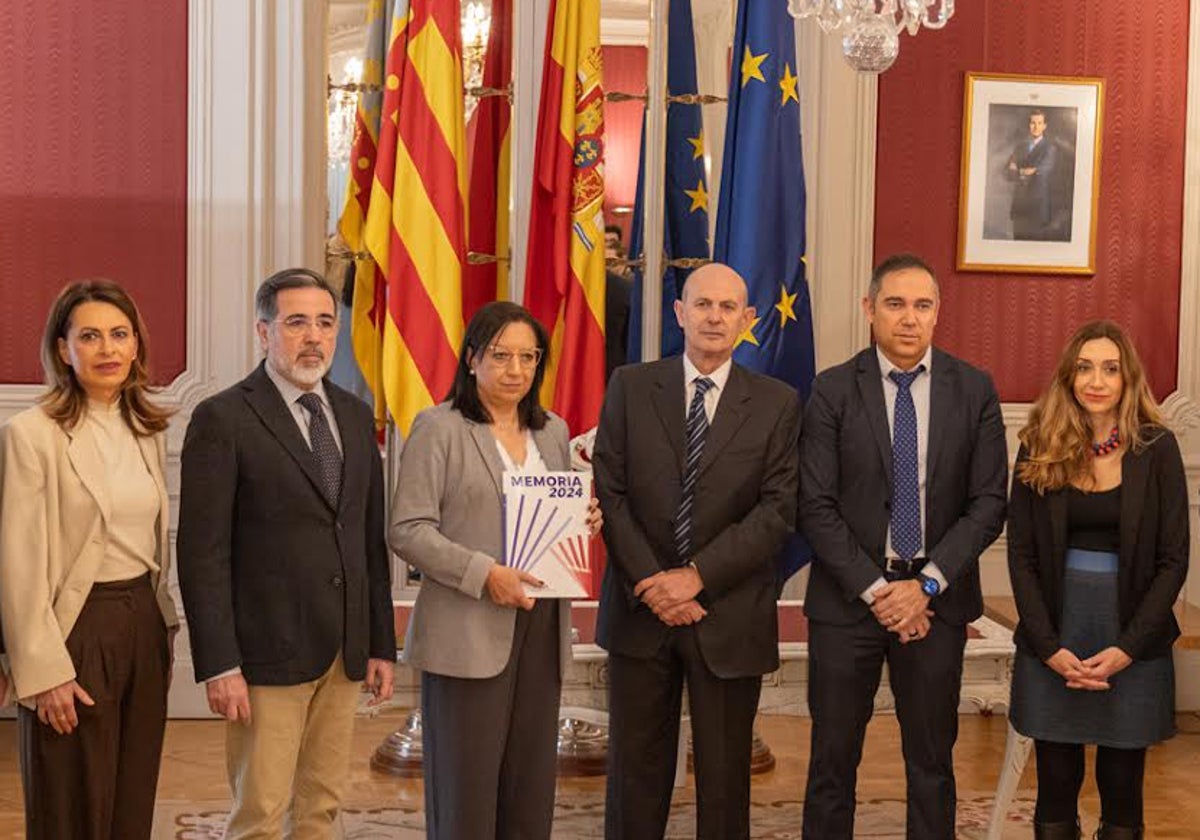 Beut, en el centro, entrega a Llanos Massó, presidenta de Les Corts, la memoria de la Agencia.