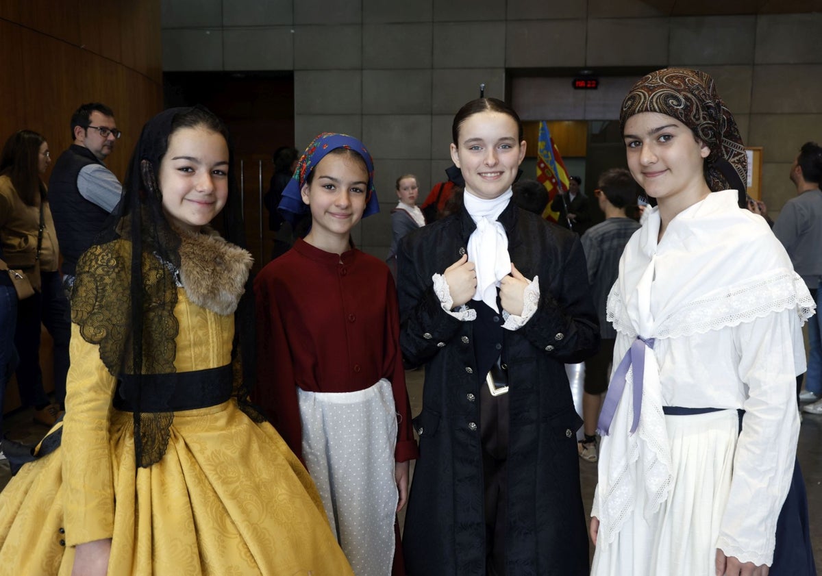 Imagen principal - Participantes de la Fiesta de los Niños de la calle San Vicente y la concejala de Fiestas, Mónica Gil, y la honorable clavariesa vicentina, María José Llorens, con el altar de Riba-roja.