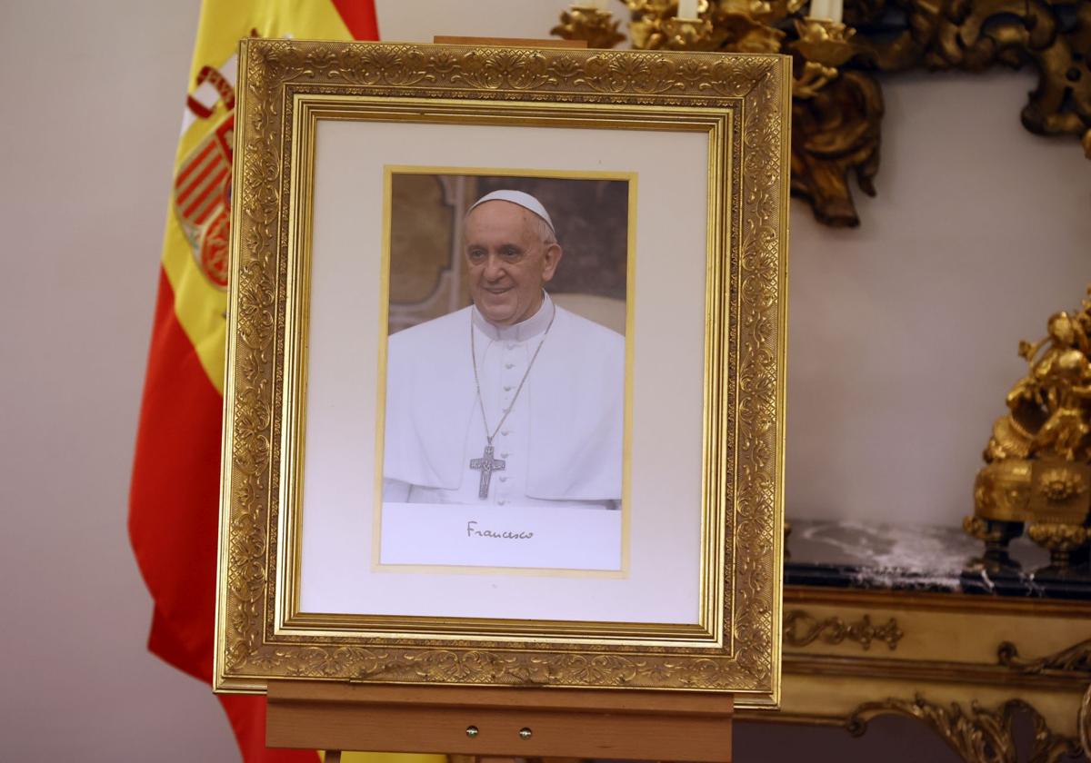 Retrato del Papa Francisco situado junto al libro de firmas en la Nunciatura Apostólica.,