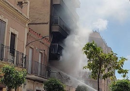 Los bomberos luchan para controlar el fuego en el edificio de Moncada.