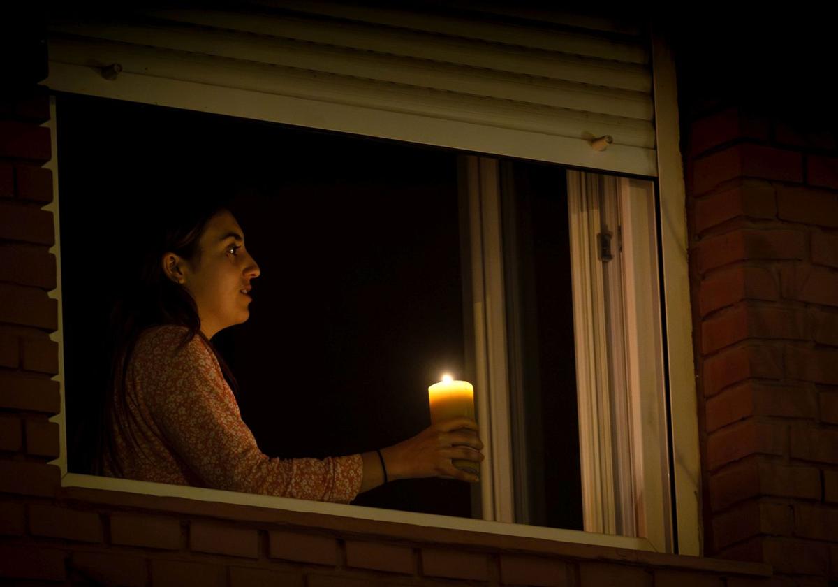 Una joven se alumbra con una vela este lunes por la noche en Ruzafa.
