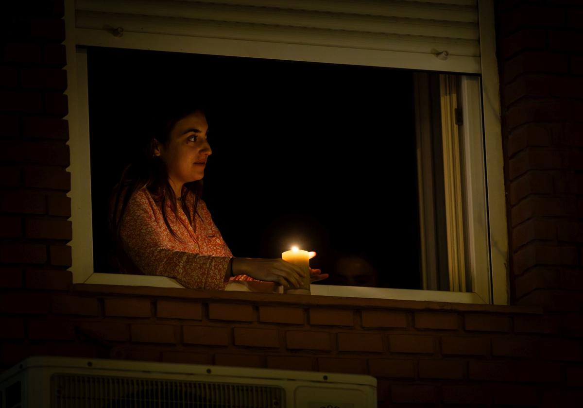 Una mujer se alumbra con una vela tras el apagón.
