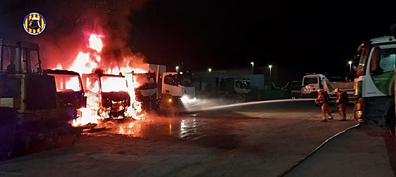 Los efectivos sofocando el fuego de los camiones.