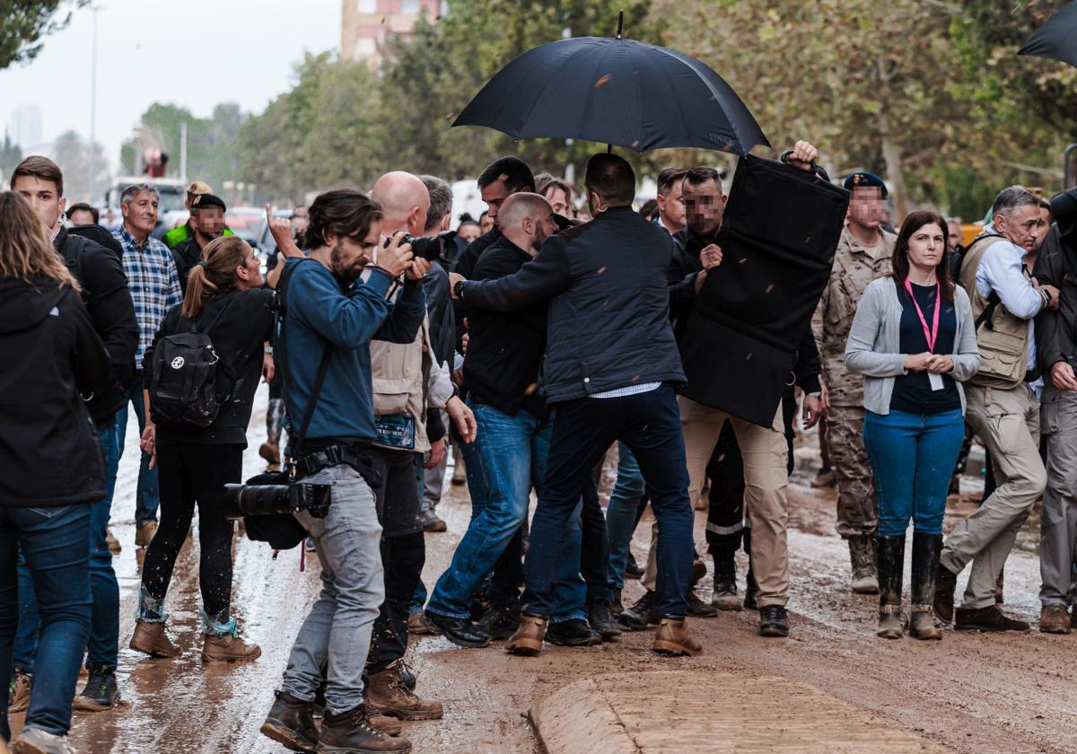 Sánchez se protege del lanzamiento de barro bajo un paraguas y rodeado de escoltas en su visita a Paiporta el 3 de noviembre.