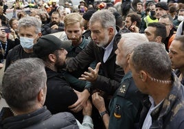 Sánchez se protege del lanzamiento de barro bajo un paraguas y rodeado de escoltas en su visita a Paiporta el 3 de noviembre.