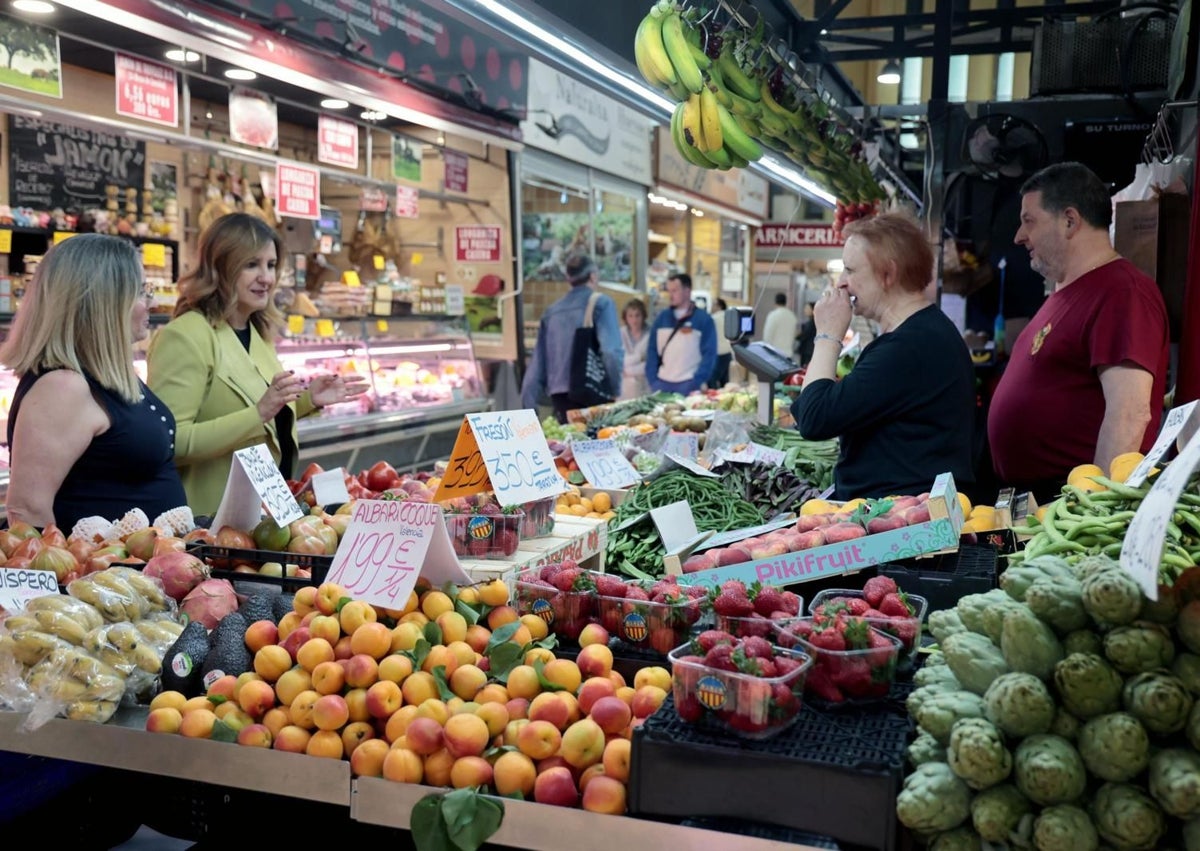 Imagen secundaria 1 - El concejal de Mercados, Santiago Ballester, con las consignas del mercado de Torrefiel y Catalá, en una frutería del mercado de Ruzafa.
