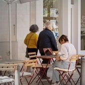 Una mujer consulta el ordenador en una terraza de un bar en Valencia.