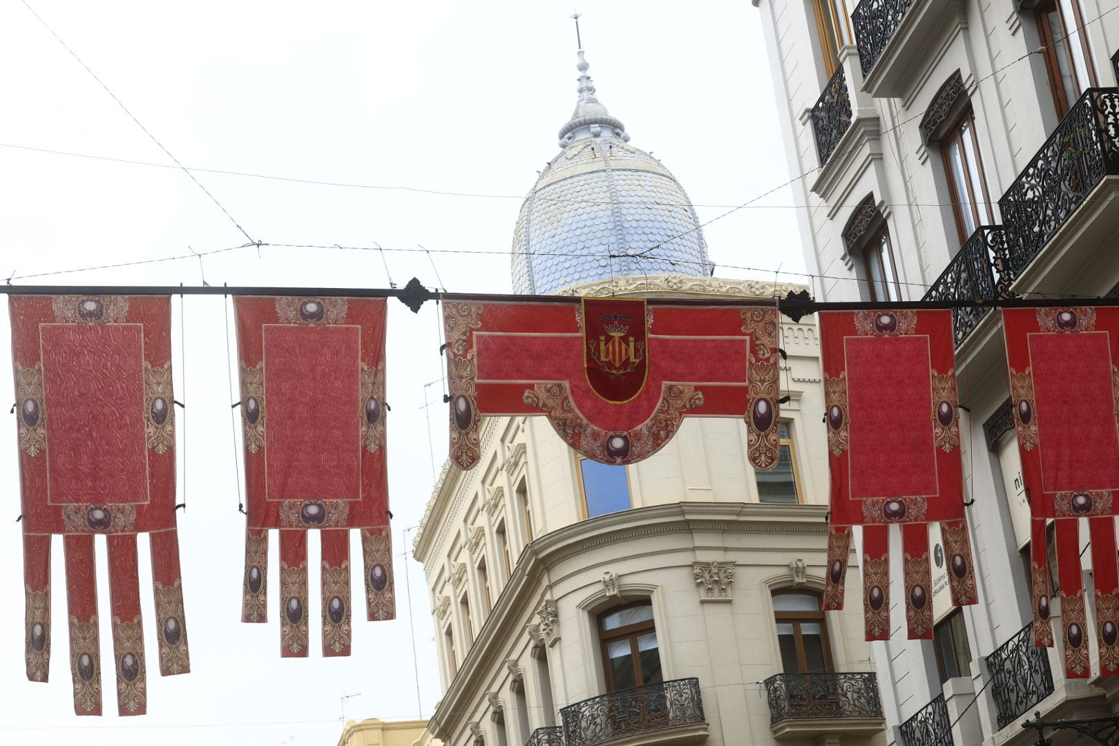Fotos del tapiz y las banderolas en honor de la Mare de Déu en Valencia
