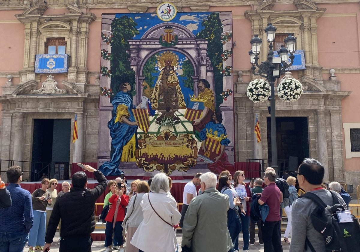 Visitantes admirando el tapiz de la Virgen que incluye este año el mensaje de 'Gracias voluntarios'.
