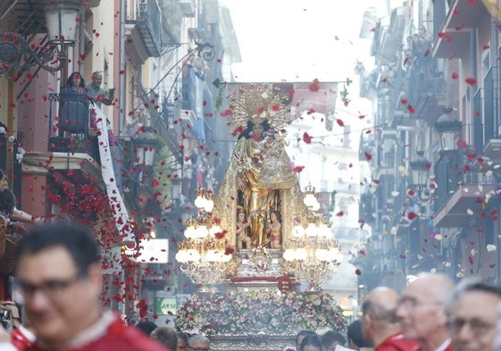 La Virgen de los Desamparados avanza por el centro de la ciudad entre pétalos al vuelo.