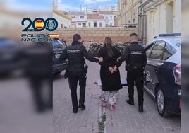 Dos agentes trasladan a la detenida a dependencias policiales.