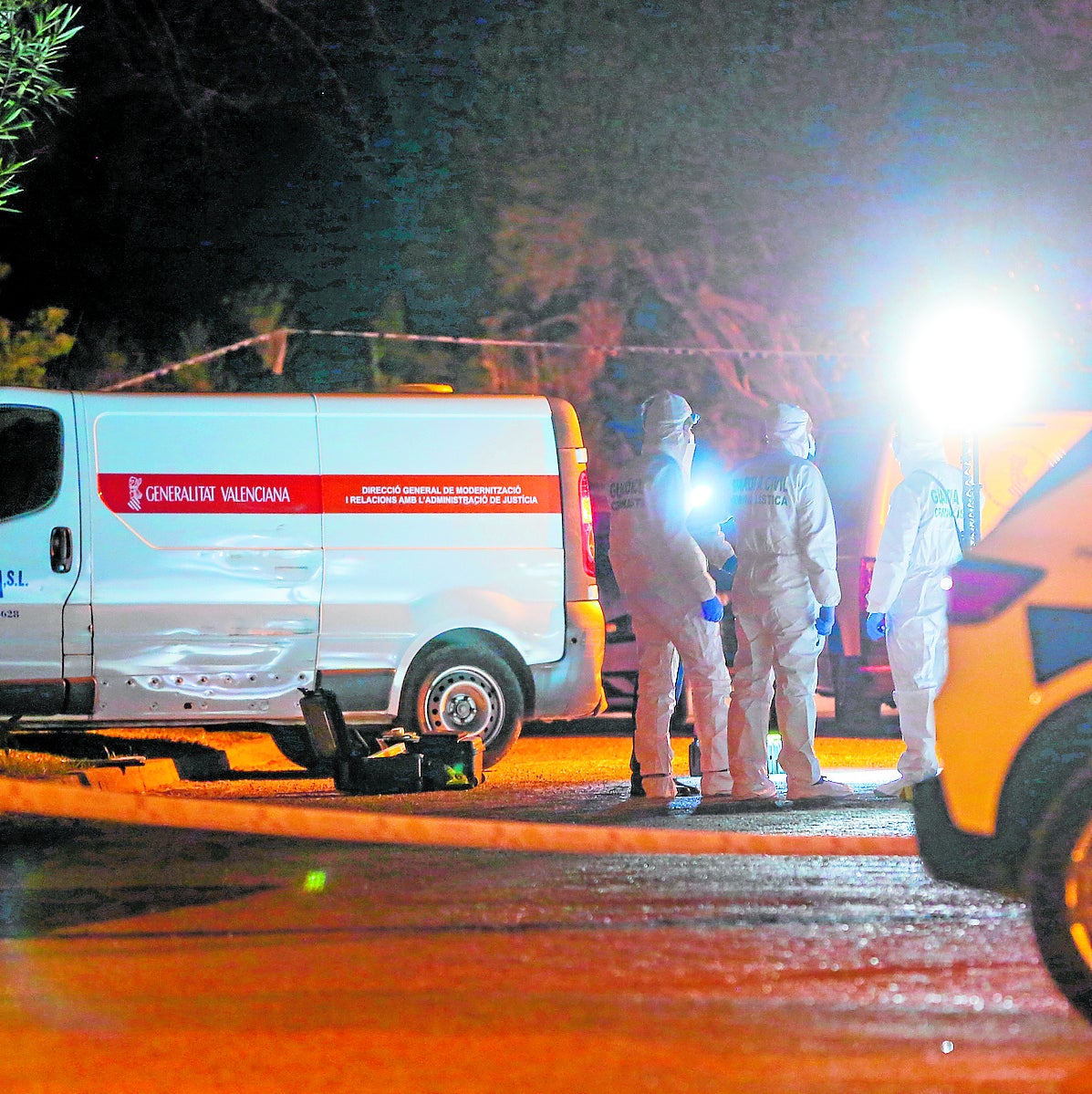 Agentes del Servicio de Criminalística, el 27 de febrero por la noche, junto al furgón del retén fúnebre.