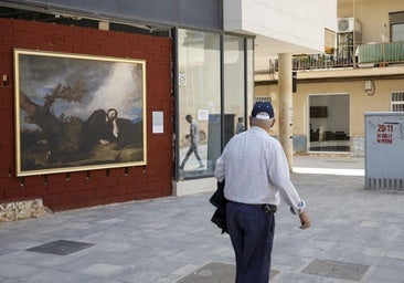 Un viandante pasa ante el cuadro de José de Ribera «El sueño de Jacob» colocado en una calle de Paiporta.
