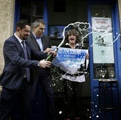 Propietarios de una administración de lotería celebran la entrega de un premio.
