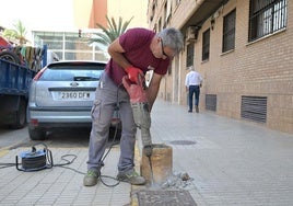Un operario retira la base de una farola.